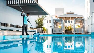 Una piscina al aire libre, sillones reclinables de piscina