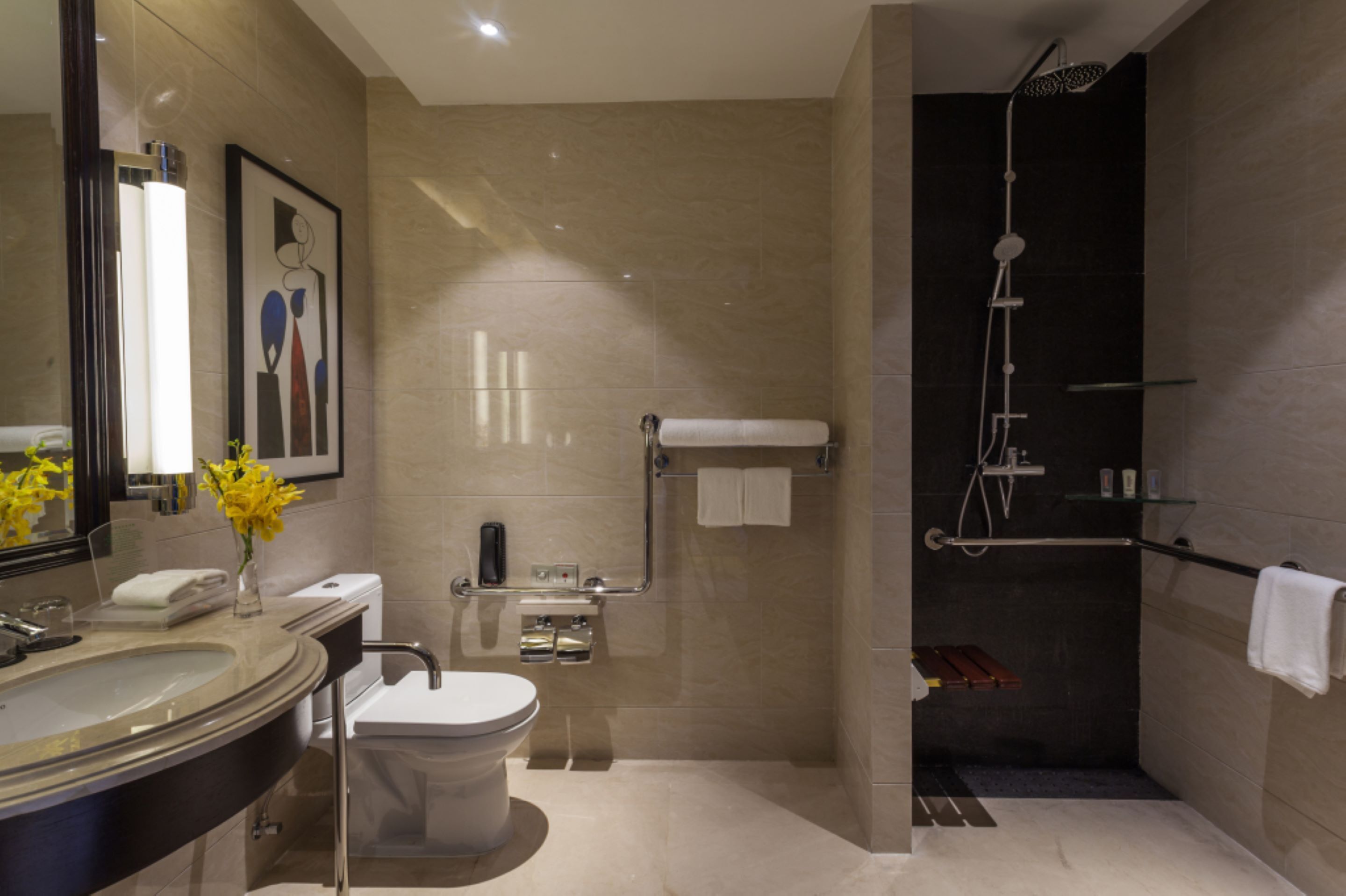 Une salle de bain moderne dotée d’un grand lavabo, de toilettes et d’un espace douche.