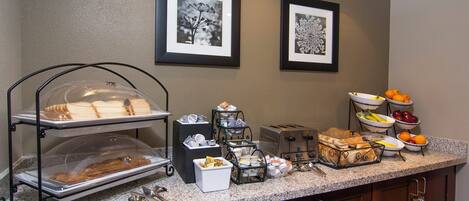 A breakfast buffet setup with various food items and a toaster.