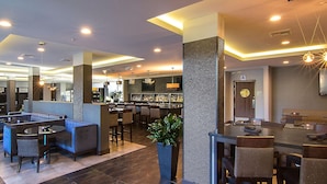 A modern hotel lobby with a bar area, seating arrangements, and a reception desk. - Staybridge Suites Carlsbad by IHG (Carlsbad)