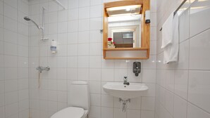 Un baño con inodoro, lavabo y ducha.