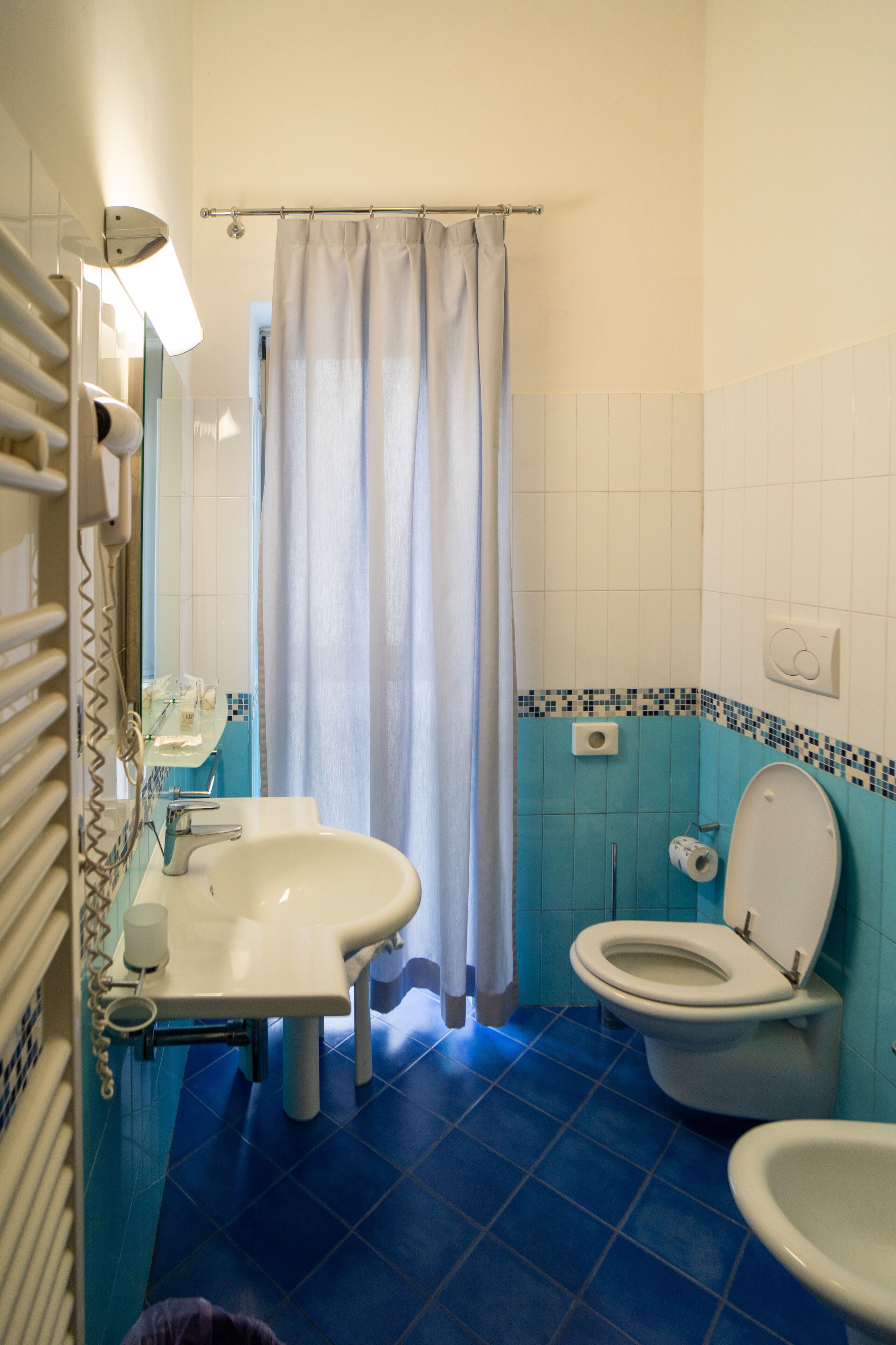A bathroom with a sink, toilet, and shower curtain.