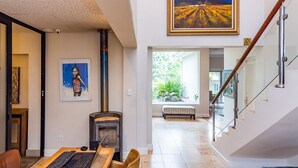 A modern interior with a fireplace, a dining area, and a staircase.
