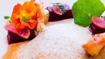A close-up of a gourmet dish with vibrant vegetables and a creamy sauce.