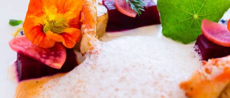 A close-up of a gourmet dish with vibrant vegetables and a creamy sauce.