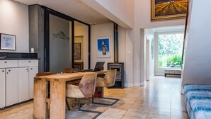 A modern kitchen with a wooden table and chairs, a built-in oven, and a view to a garden.