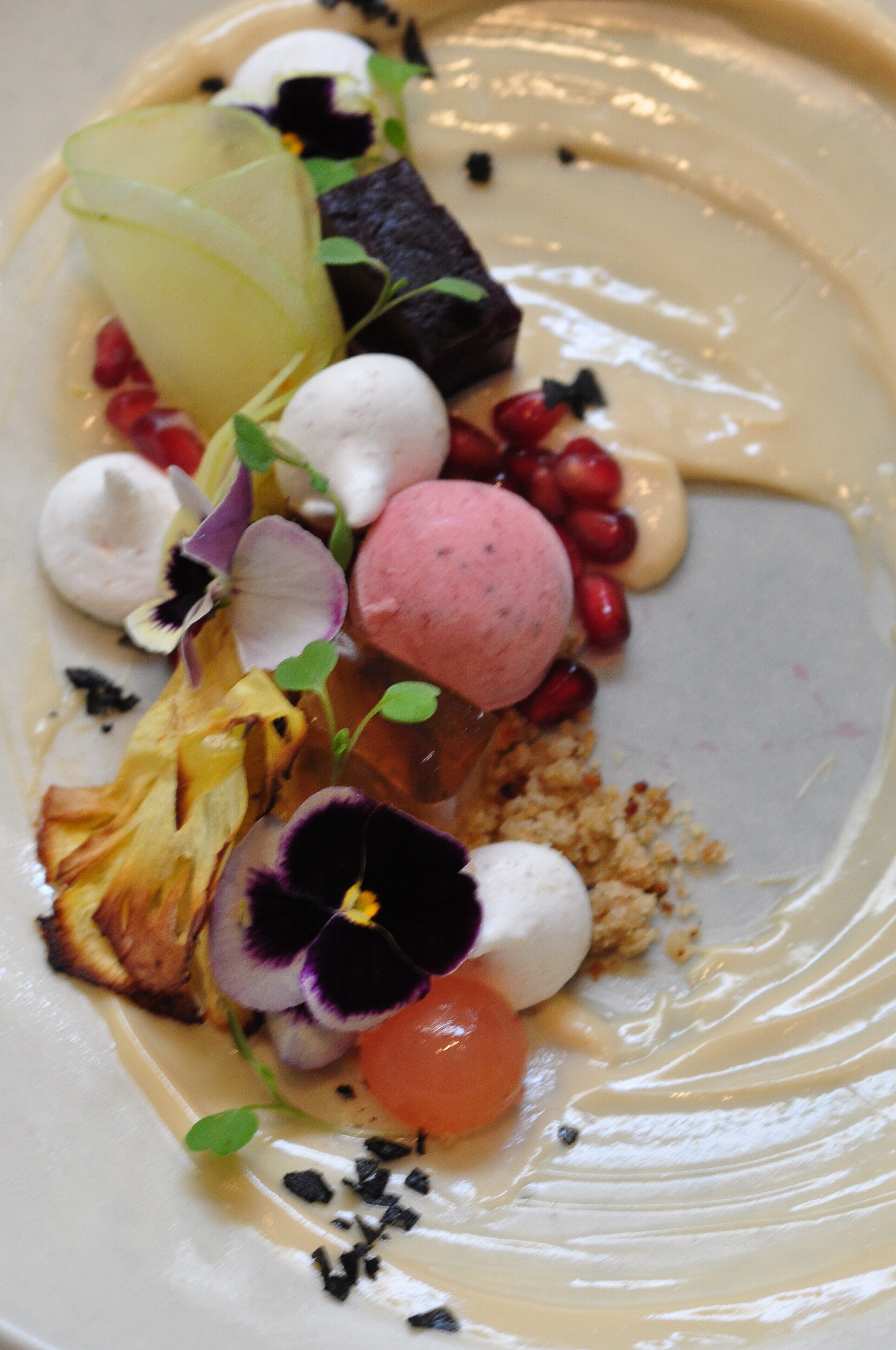 A dessert plate with various fruits, vegetables, and a dollop of cream.