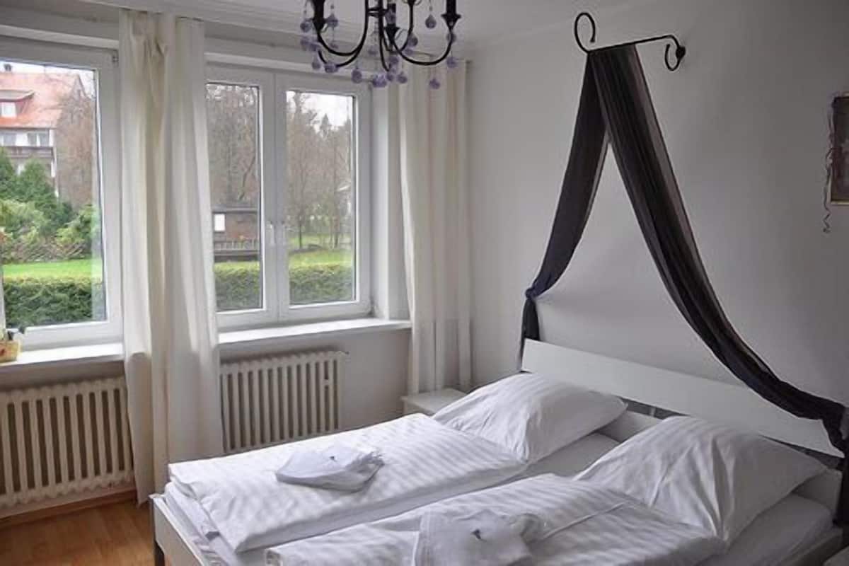 Un dormitorio con una cama, una ventana y un radiador.