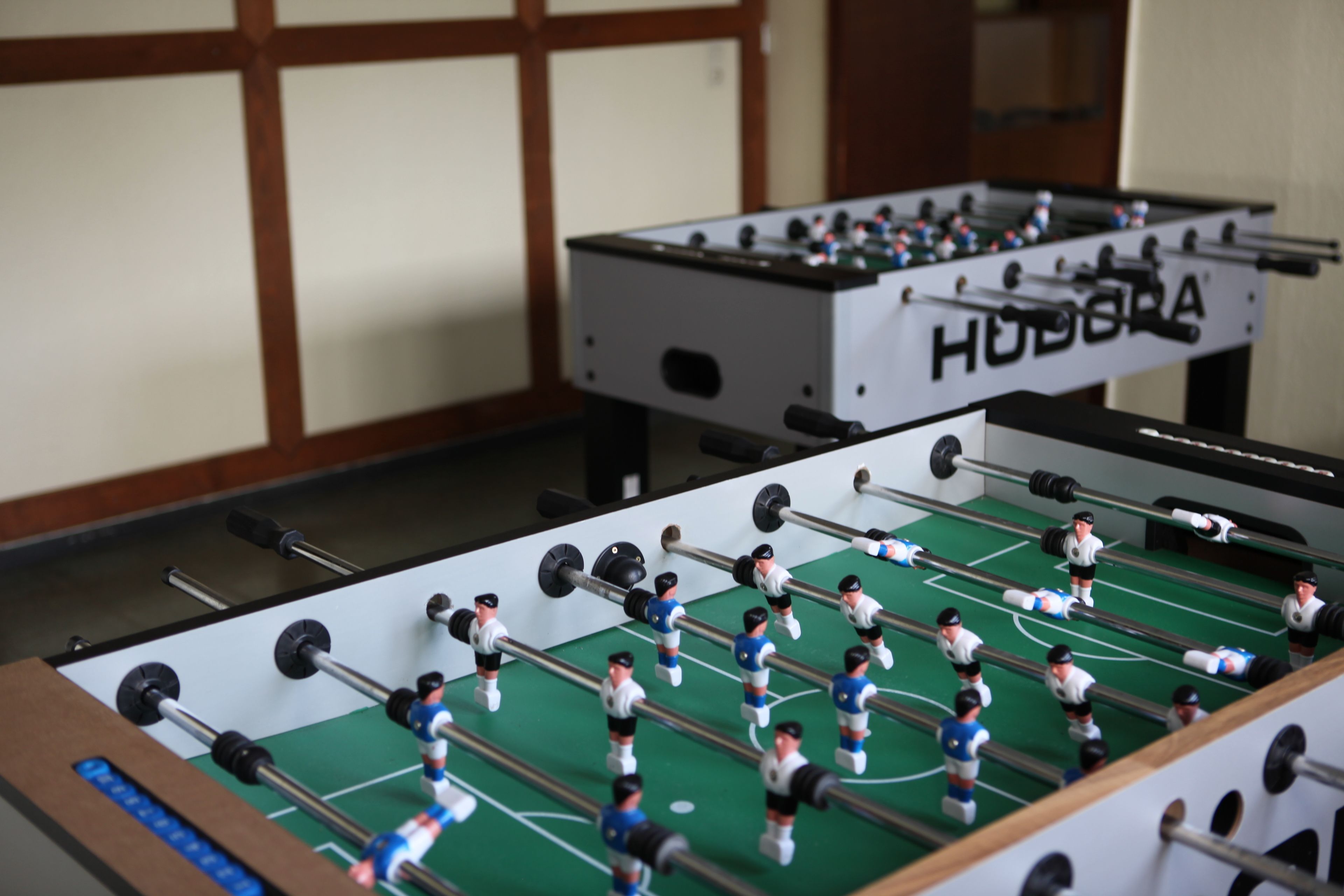A foosball table with players in white and blue uniforms.