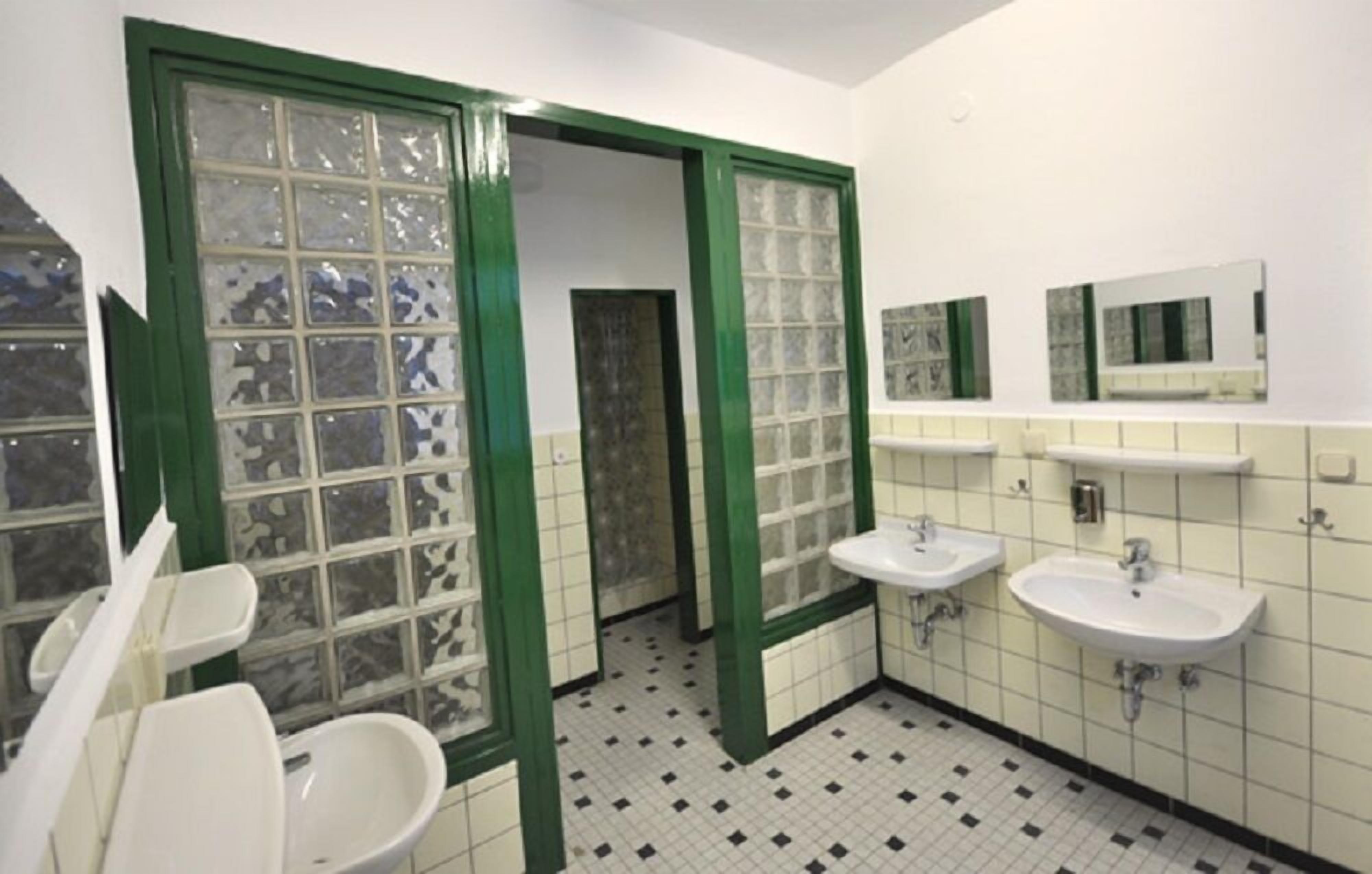 Een badkamer met twee wastafels, een spiegel en een toilet.