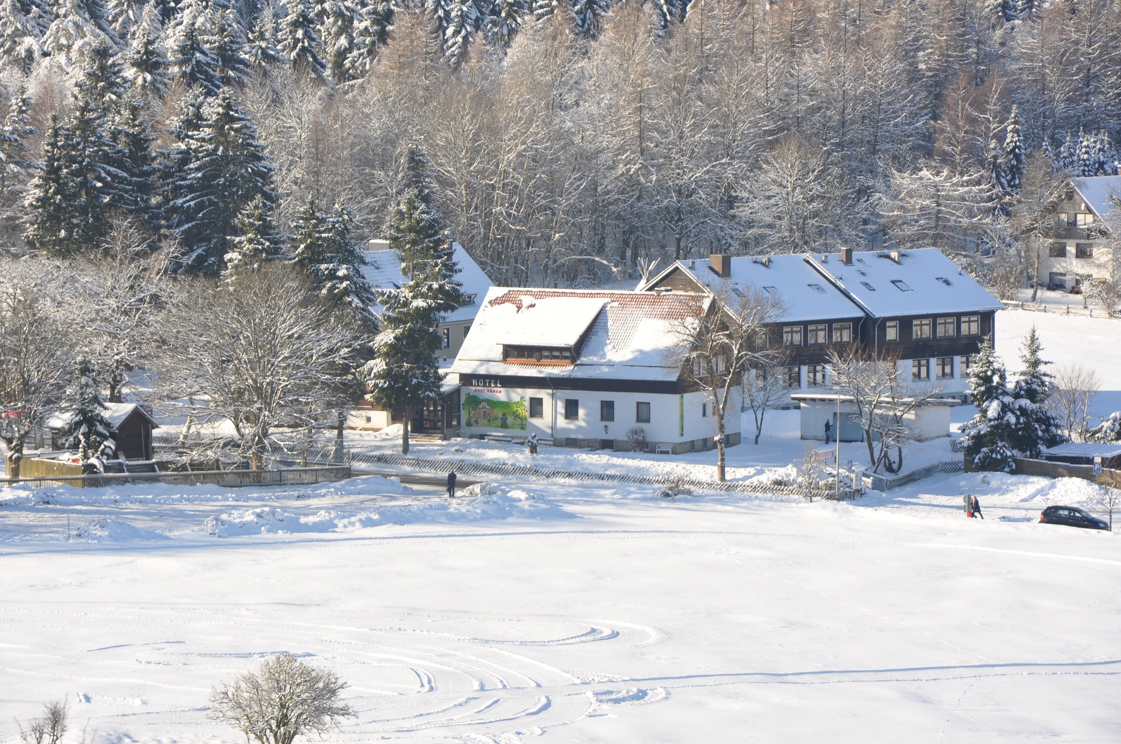 A hotel with a snow-covered roof and a large windowed facade.