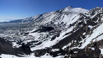 Una montaña con laderas nevadas y terreno rocoso.