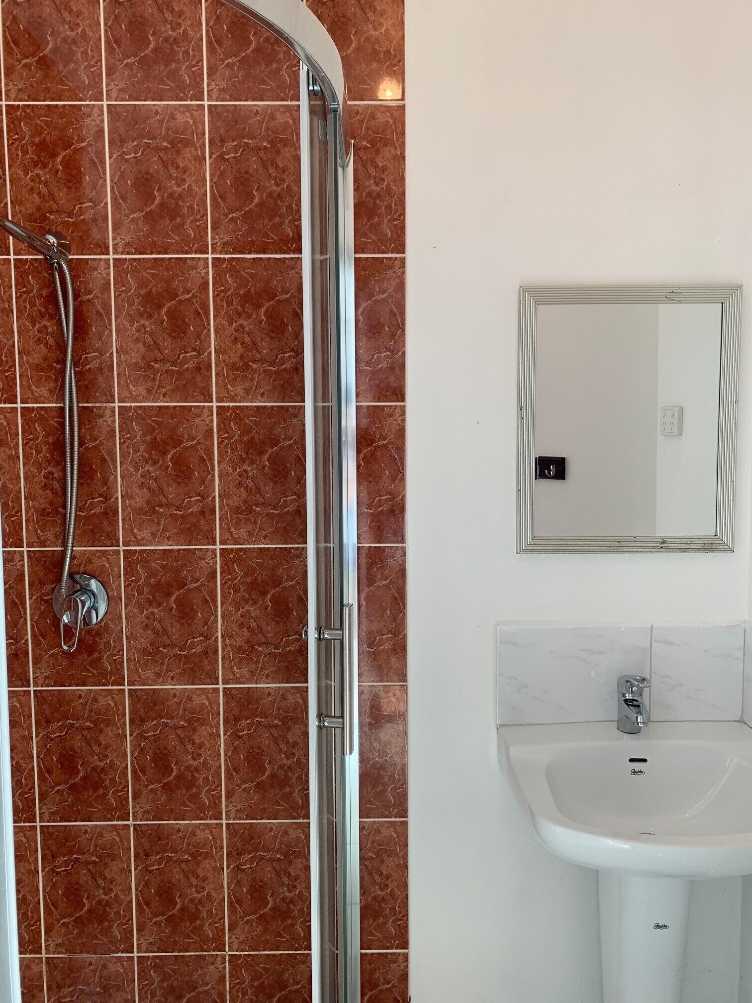 A bathroom with a shower, a sink, and a mirror.