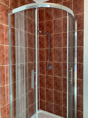 Habitación estándar con 1 cama doble o 2 individuales | Baño | Ducha, cabezal de ducha tipo lluvia, secador de pelo y toallas