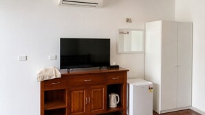 A room with a wooden cabinet, a television, a white refrigerator, and a wardrobe. - Beaconsfield Lodge Motel (Beaconsfield)