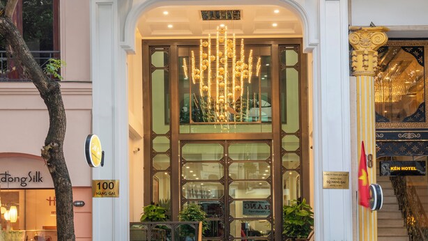 The exterior of SQ HANG GAI Hotel & Spa, featuring a grand entrance with a chandelier, potted plants, and a staircase leading to the upper floors. - SQ HANG GAI HOTEL & SPA (Hanoi)