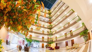 A multi-level atrium with a checkered floor, multiple balconies, and indoor plants. - Three Seasons Bangkok (Bangkok)