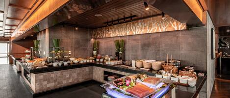 A modern buffet setup with a variety of food items and a central display of fresh produce.