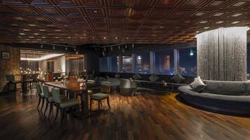 A modern interior with a wooden floor, a round dining table, and a large sofa.