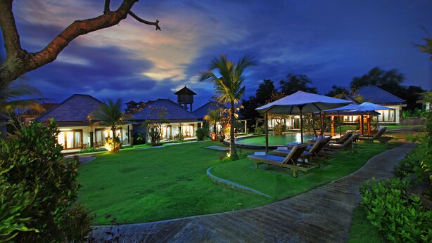 A well-maintained lawn with a pool area, lounge chairs, and a gazebo. - The Brothers Villas Padang Padang (Pecatu)