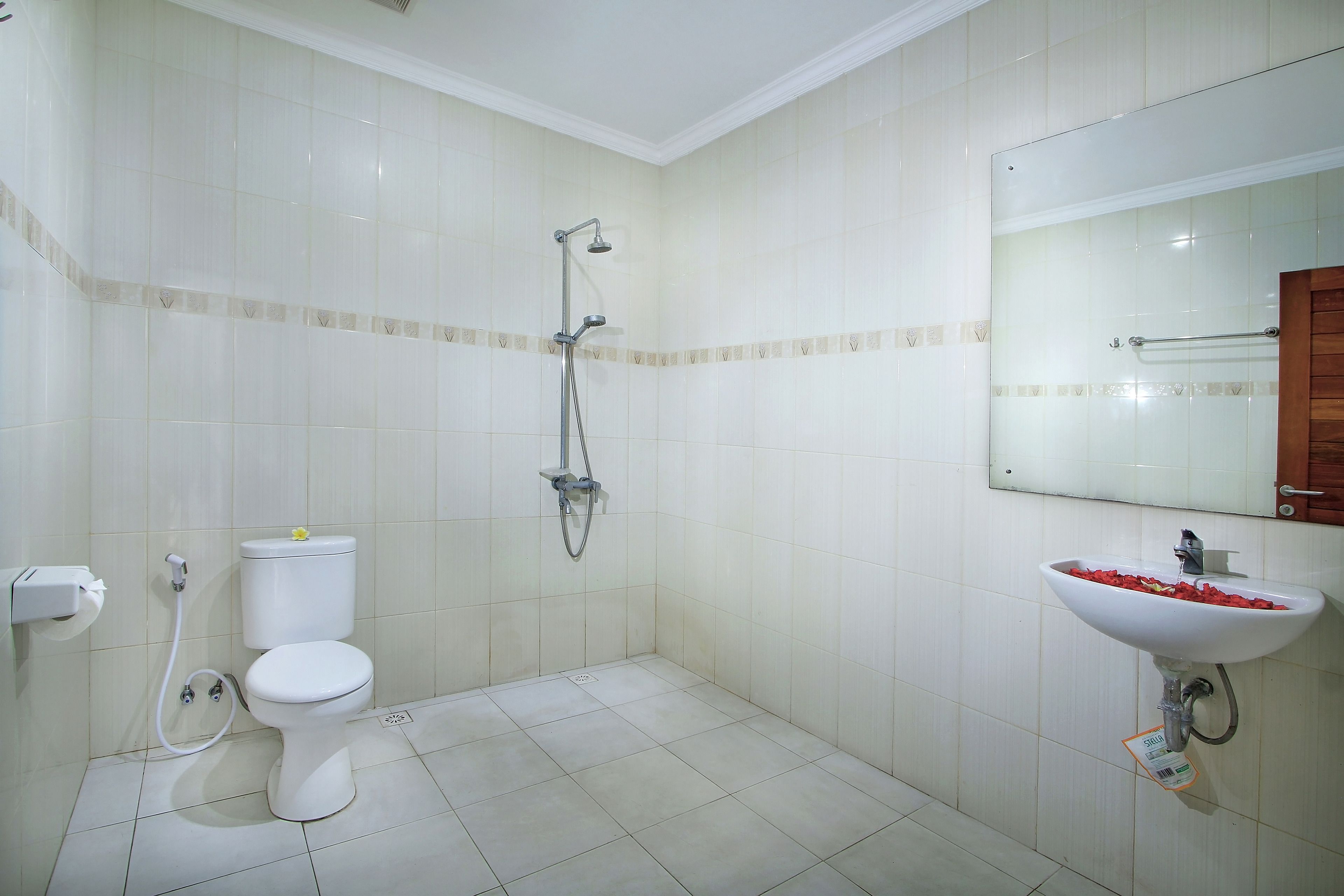 A bathroom with a toilet, shower, and sink.