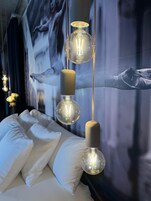 Una cama con sábanas blancas y un mural en la pared.
