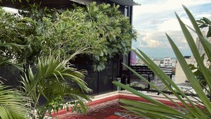 A rooftop pool area with a view of the city skyline, surrounded by lush greenery and modern architecture. - Now Hotel Cali - Adults Only (Cali)