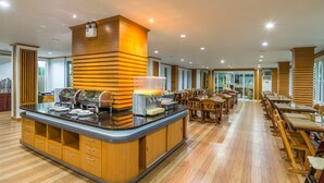 Zona de buffet con una isla central, paneles de madera y un mostrador de vidrio.