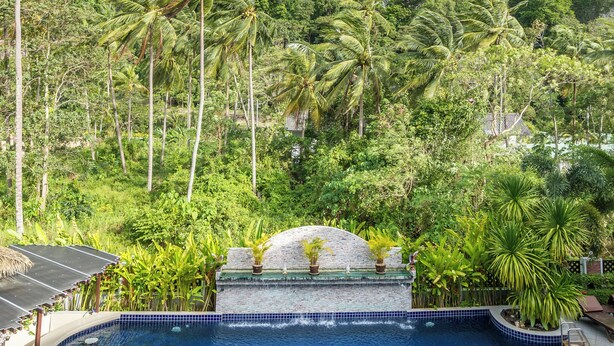 Una piscina con vista a un paisaje montañoso y palmeras.
