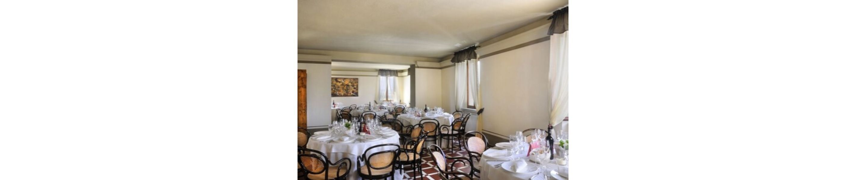 A dining area with tables set for a meal, chairs, and a painting on the wall.
