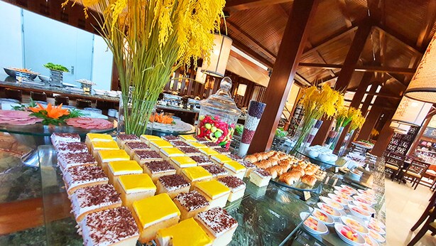 A buffet with various food items and a large floral arrangement. - Halong Palace Hotel (Bai Chay)