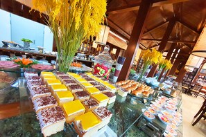 A buffet with various food items and a large floral arrangement. - Halong Palace Hotel (Bai Chay)