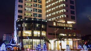 A multi-story hotel with a prominent "PALACE HOTEL" sign, featuring a modern architectural design with a glass facade and illuminated windows. - Halong Palace Hotel (Bai Chay)