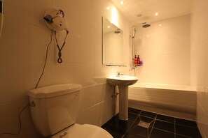 A bathroom with a toilet, sink, and bathtub. - Hotel violet (Goyang)
