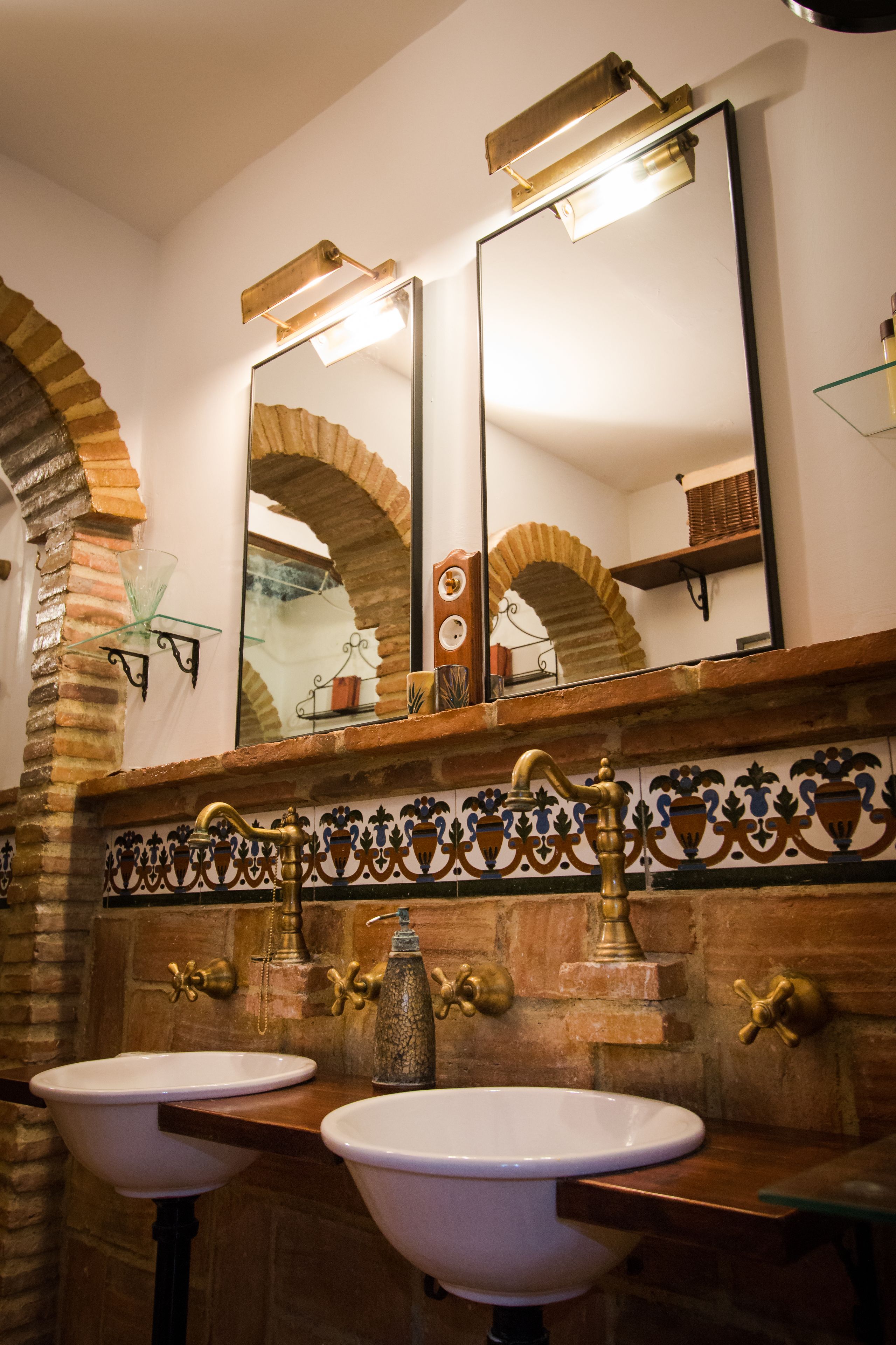 A bathroom with two sinks, a mirror, and a decorative tile backsplash.
