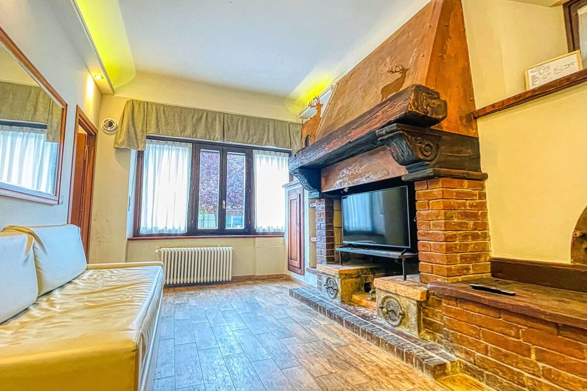 A living room with a fireplace, a sofa, and a television.