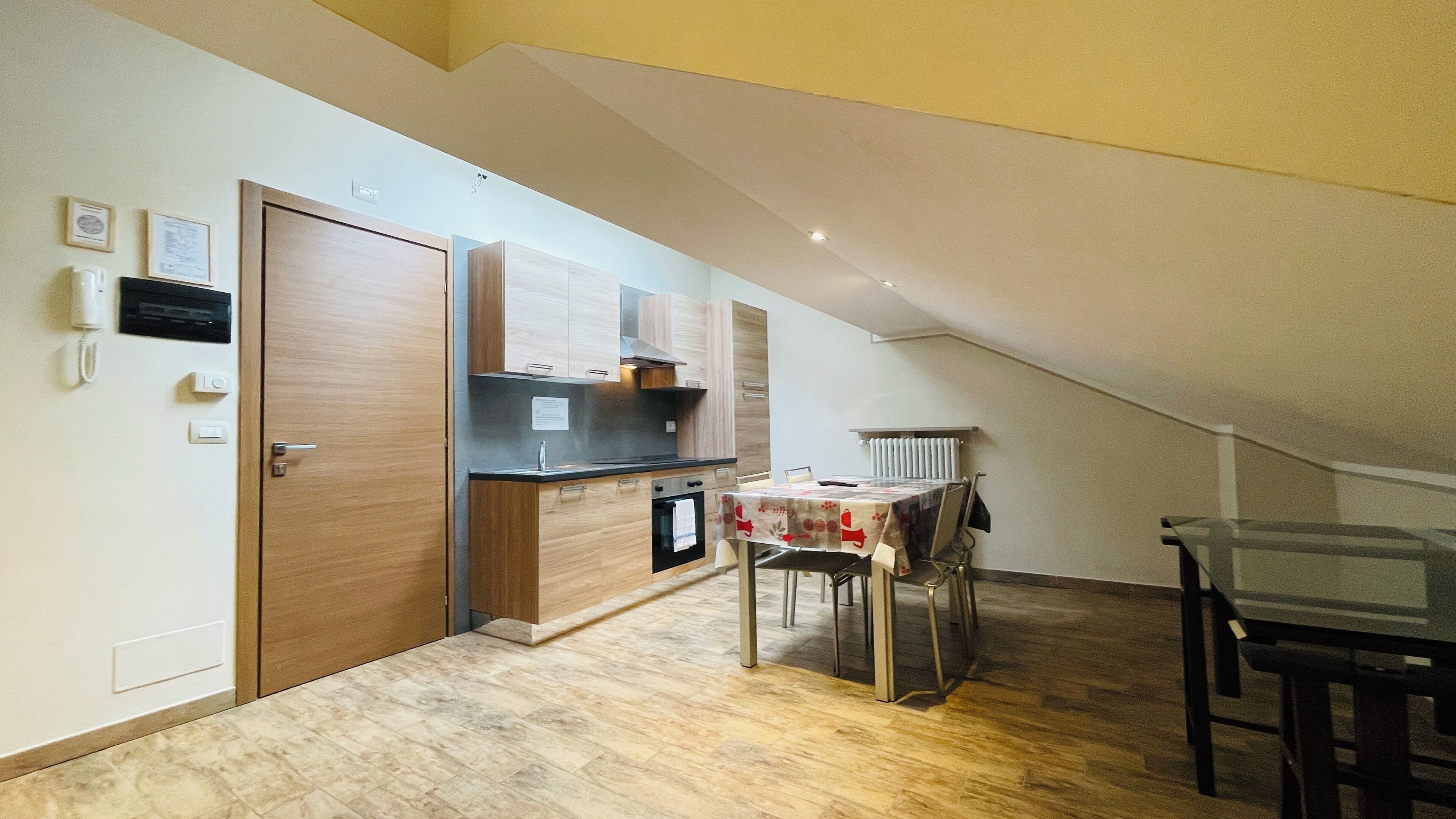 Una cucina funzionale con mobili in legno, forno integrato e un tavolo con sedie.