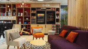 A modern interior with a library, shop, and seating area. - Aparthotel Adagio Access Dijon République (Dijon)
