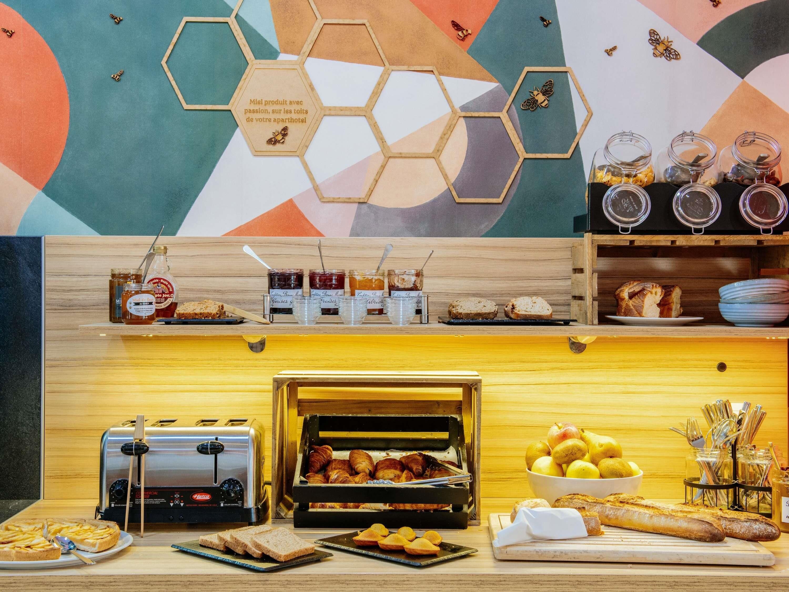 A breakfast buffet with various food items, a toaster, and a bread display.