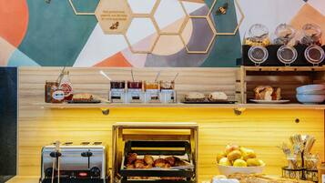A breakfast buffet with various food items, a toaster, and a bread display.
