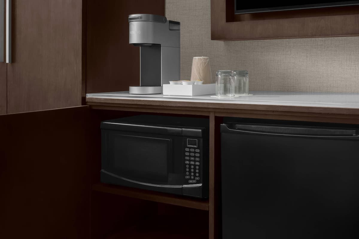 Una cocina equipada con cafetera, microondas y lavavajillas.