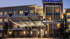 A Wyndham hotel with a covered entrance, brick facade, and large windows.