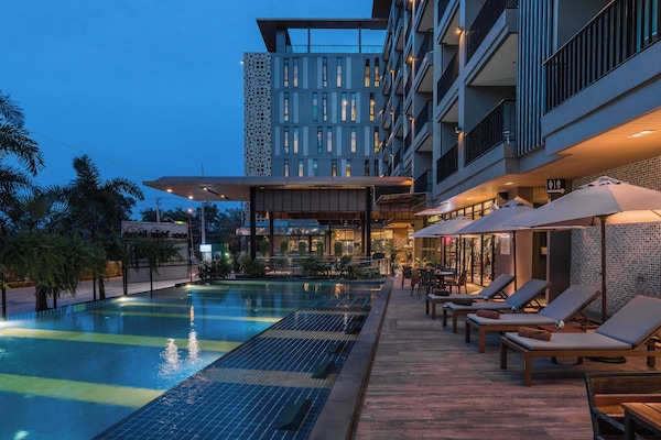 Una piscina al aire libre, sombrillas, tumbonas