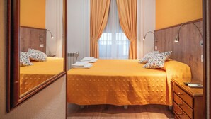 A hotel room with a large bed, two bedside tables, a mirror, and a window with curtains. - Hostal Edreira (Madrid)