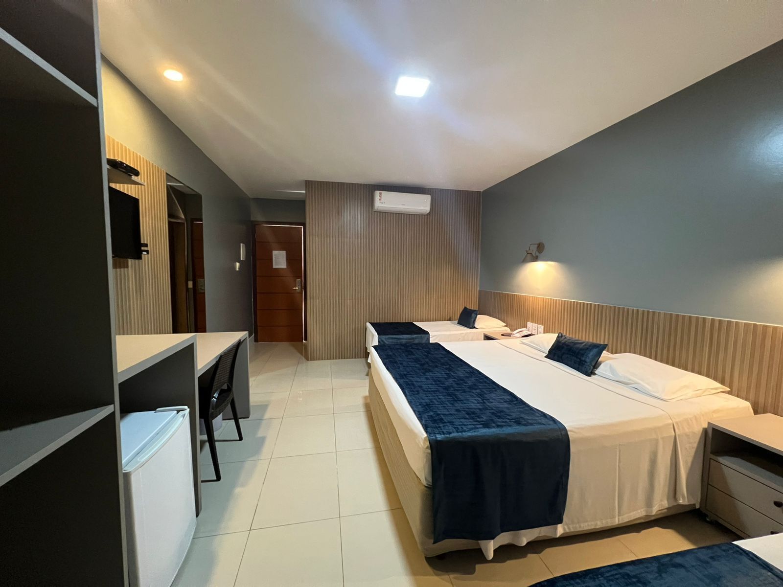 Een hotelkamer met twee bedden, een bureau en een kledingkast.