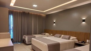 A modern hotel room with two beds, a desk, and a chair. - Hotel Adventure (São Luís)