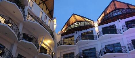 A multi-story hotel with balconies, large windows, and a modern architectural design.