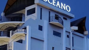 A modern building with the name "OCEANO" illuminated on the facade.