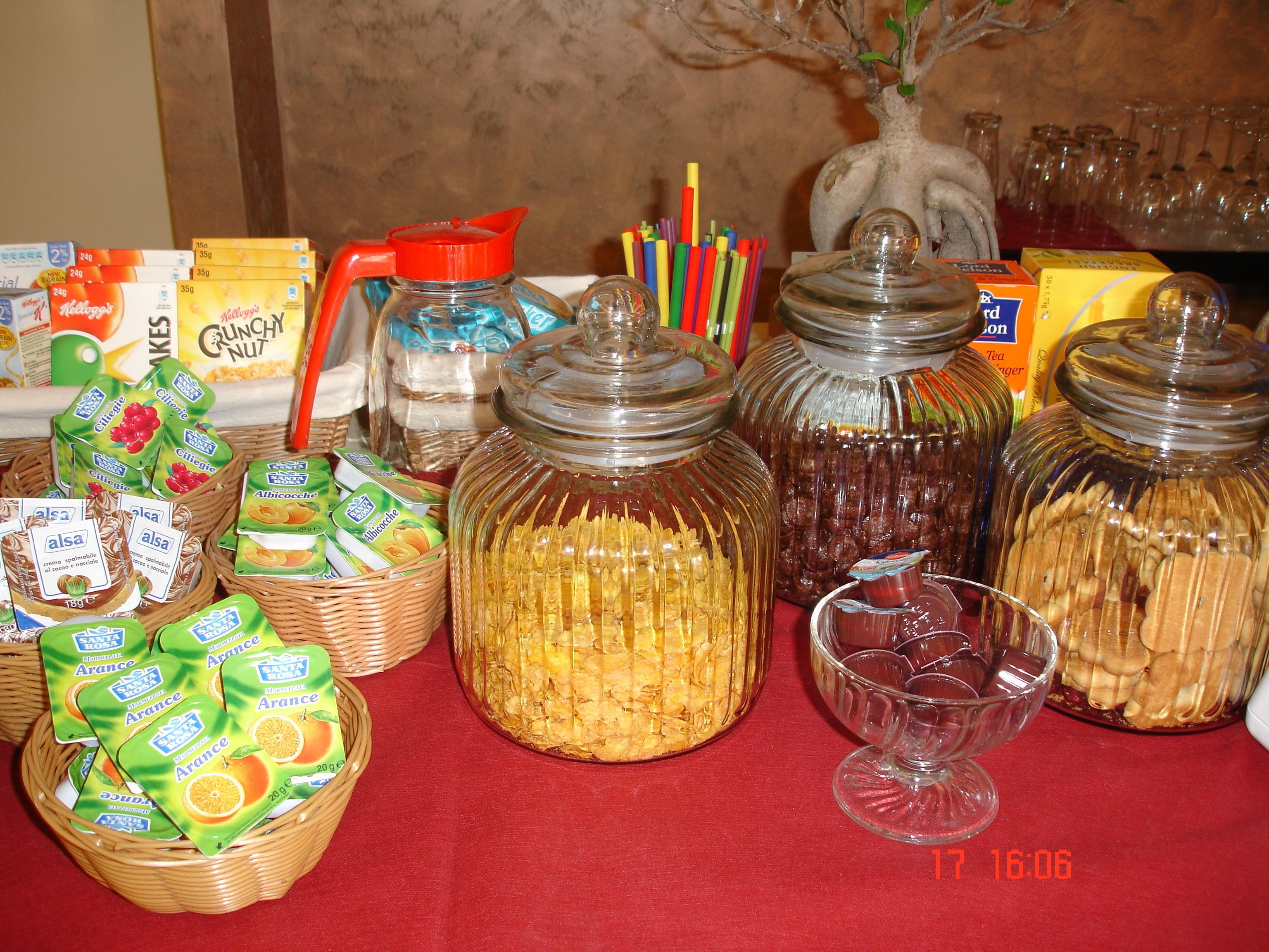 A table with various food items, including jars of preserves and baskets of snacks.
