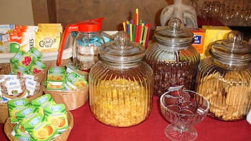 A table with various food items, including jars of preserves and baskets of snacks.
